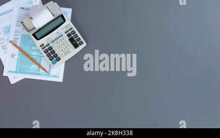 DÉCLARATION DE revenus DES particuliers AUX ÉTATS-UNIS avec calculatrice rétro et crayon sur bureau gris avec espace de copie Banque D'Images