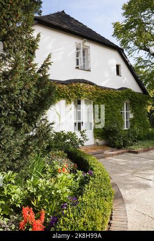 Vue partielle de la maison de Frédéric Chopin avec bordure en pierre de diverses plantes à la fin de l'été, Zelazowa Wola, Pologne Banque D'Images