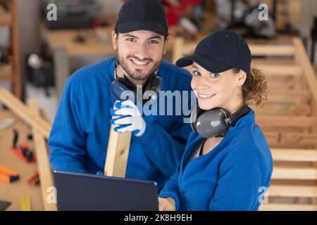 travailleur masculin enseignant aux femmes apprentis comment utiliser une machine Banque D'Images