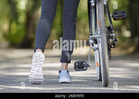 vue courte d'une femme poussant un vélo Banque D'Images