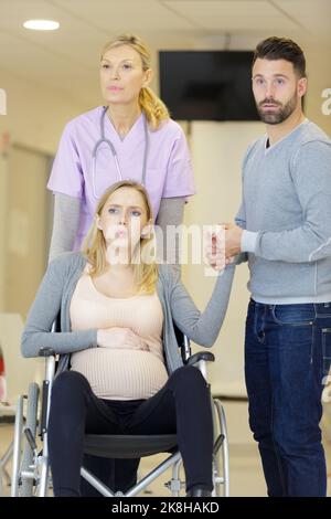 femme enceinte assise sur un fauteuil roulant avec son mari Banque D'Images