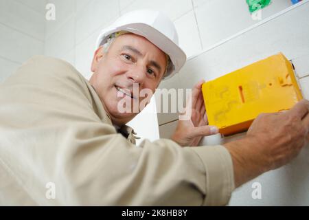 réaliser l'installation d'un boîtier de commande avec un casque blanc Banque D'Images