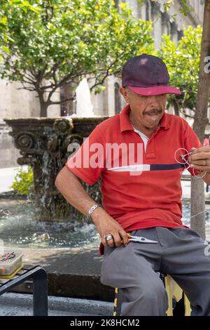 artisan dans la rue faisant des figurines de vélo avec fil, fait main métal figurines mexique Banque D'Images