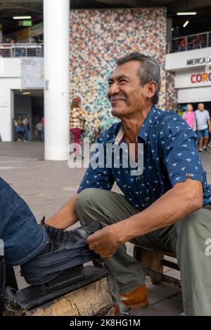 chaussures dans un lavabo avec de l'eau savonneuse. nettoyage des chaussures dans la rue, latin old man, Banque D'Images