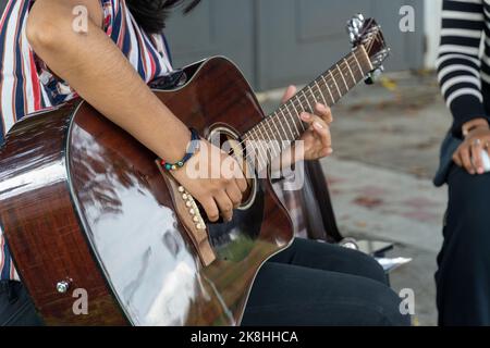 latina femme jouant de la guitare dans la rue, jeune femme brunette, amérique latine Banque D'Images