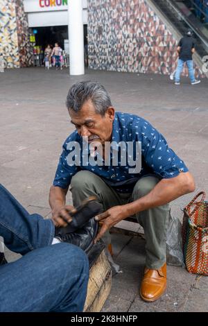 chaussures dans un lavabo avec de l'eau savonneuse. nettoyage des chaussures dans la rue, latin old man, Banque D'Images