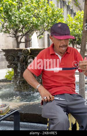 artisan dans la rue faisant des figurines de vélo avec fil, fait main métal figurines mexique Banque D'Images