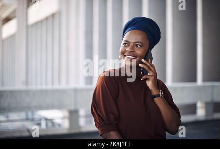 Restez connecté, restez en contact. Une jeune femme d'affaires utilise un smartphone sur fond de ville. Banque D'Images