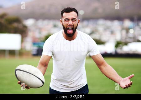 Les joueurs de rugby ne parlent pas, ils rôrent. Portrait d'un jeune homme enthousiaste jouant un match de rugby. Banque D'Images