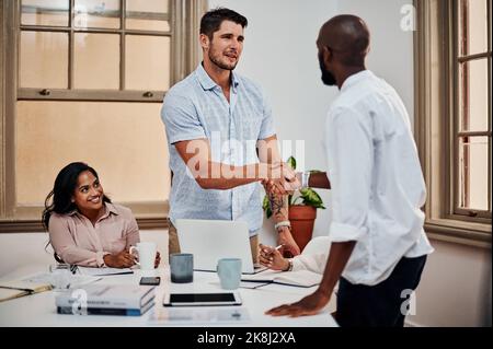 Le genre de partenaire que vous voulez de votre côté. Deux jeunes hommes d'affaires qui se branle dans un bureau moderne. Banque D'Images
