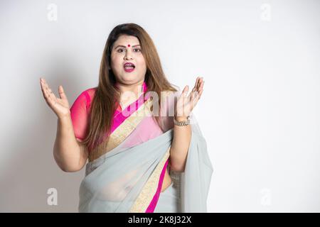 Surprise femme indienne en surpoids portant la saree levant les deux mains isolées sur fond blanc, choqué femme asiatique avec la bouche ouverte criant, noir f Banque D'Images