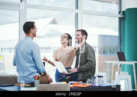 Ajouter une étincelle de créativité à leurs idées. Un groupe de jeunes designers ayant une discussion dans un bureau. Banque D'Images