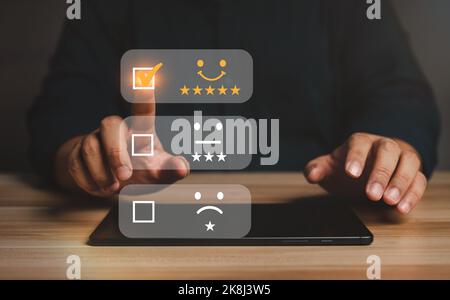 L'homme d'affaires attribue des notes à l'expérience de service sur un smartphone, aux évaluations et aux évaluations de satisfaction des fournisseurs de services, au concept de satisfaction et au client Banque D'Images