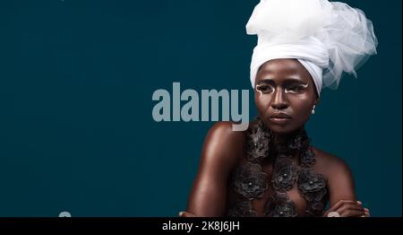 Sa beauté parle d'elle-même. Photo en studio d'une jeune femme attrayante posant dans une tenue africaine traditionnelle sur un fond bleu. Banque D'Images