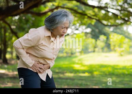 Malade asiatique senior femme stomachache ou gastro-entérologues, les personnes âgées ont un problème d'estomac, la pancréatite aiguë cause des maux d'estomac, symptômes gastrint Banque D'Images