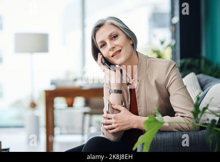 Conclure la vente par téléphone. Portrait court d'une femme d'affaires mûre et attrayante assise seule et parlant sur son téléphone portable dans son bureau à domicile. Banque D'Images