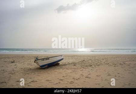 Bateau unique sur la plage au coucher du soleil, Espagne. Banque D'Images