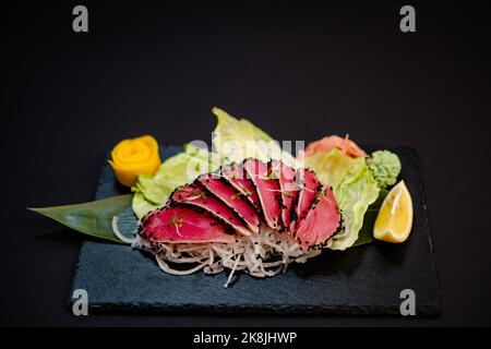 Thon maguro sashimi sur une assiette noire Banque D'Images