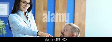 Femme et homme au bureau discutent de quelque chose, la femme pointe avec le doigt sur l'écran Banque D'Images