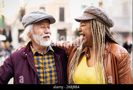 Joyeux couple multiracial senior s'amusant en ville - personnes âgées et concept de relation d'amour Banque D'Images