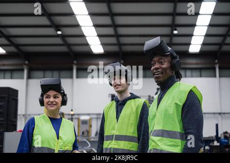 Équipe d'ingénieurs ayant l'expérience de la simulation avec des lunettes futuristes de réalité virtuelle à l'intérieur de l'usine robotique - l'industrie technique et le concept métaverse Banque D'Images