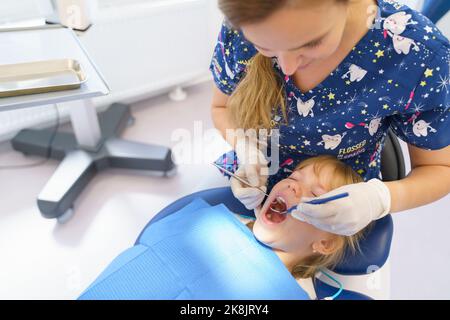 Jeune femme dentiste faisant un examen préventif petite fille. Banque D'Images