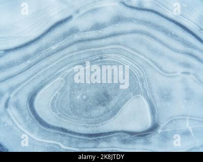 Texture abstraite de la glace. Un réseau de fissures sur un morceau de glace bleue Banque D'Images