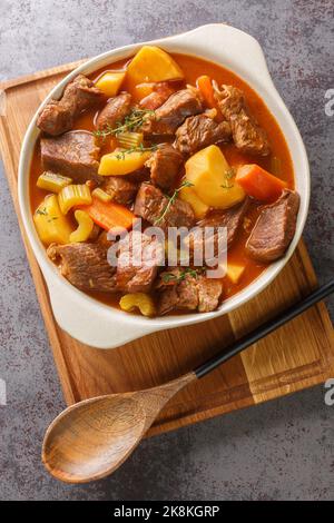 Ragoût de bœuf irlandais et de Guinness avec légumes de saison dans la casserole sur la table. Vue verticale du dessus Banque D'Images