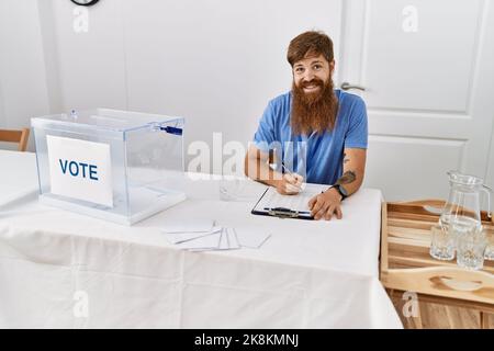 Un jeune homme de parti politique souriant, souriant, est content de travailler au collège électoral. Banque D'Images