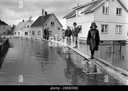 Lillestrøm 19660523 Flood frappe Lillestrøm hard. La plupart des rues sont maintenant sous-marines, et dans certaines rues, des ponts étroits de bois sont construits pour que les gens puissent arriver. Voici une barge avec des enfants et des adultes en vêtements de pluie. Photo: NTB / NTB Banque D'Images