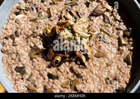 risotto rouge aux champignons sauvages dans un bol en bolete décoré de parasol frit. Photo de haute qualité Banque D'Images