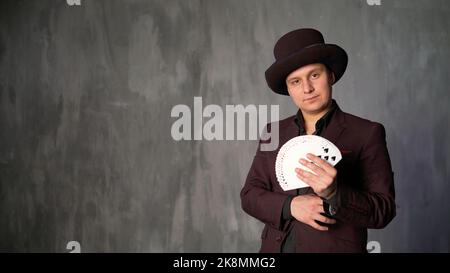 Un magicien effectuant un tour de carte. Jouer aux cartes dans les mains d'un magicien. Le magicien change de cartes, gros plan. Banque D'Images