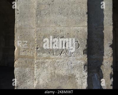 '1764 Nicolas' au 11 place des Vosges, à Paris, dans le quartier du Marais, sur l'un des piliers de ses célèbres arcades, on peut voir ce qui est considéré comme l'un des plus anciens graffitis de Paris. Sur ce graffiti daté de 1764 et gravé dans la pierre (qui l'a certainement permis d'être conservé jusqu'à aujourd'hui), on peut lire le premier nom 'NICOLAS' qui en est l'auteur, Nicolas Edme Restif de la Breton, un écrivain. Il les a créés dans tout Paris et les a publiés dans son livre "mes inscriptions". Seul celui sur la place des Vosges reste aujourd'hui Banque D'Images