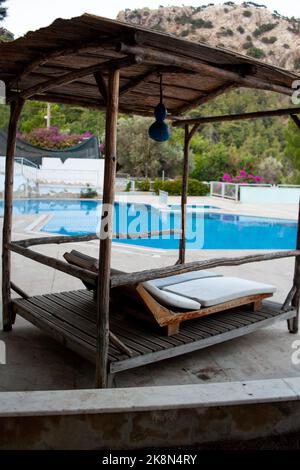 Chaises longues sous un support à baldaquin près de la piscine. Chaises longues dans la piscine de l'hôtel. Banque D'Images