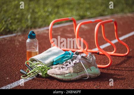 Équipement sportif pour une formation de qualité et un plaisir suffisants. Terrain de jeux sportif en plein air. Style de vie du jeu. Serviette, corde à sauter, t-shirt, haies, serviette et dri Banque D'Images