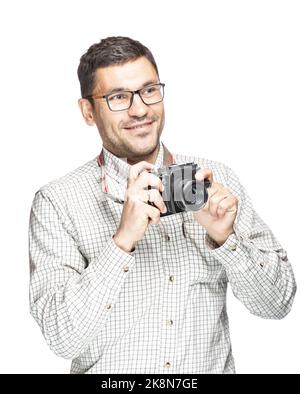 Beau homme en lunettes et une chemise à carreaux, souriant et prenant des photos avec un appareil photo vintage Banque D'Images