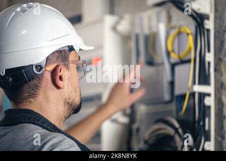 Man, un technicien en électricité travaillant dans un tableau de commutation avec des fusibles. Banque D'Images