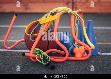 Équipement sportif pour une formation de qualité et un plaisir suffisants. Basket-ball, corde à sauter, haies, cônes bleus, élastiques, expandeurs. Jeux de sport en extérieur Banque D'Images