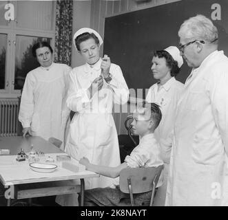 NES à Romerike, 19561016: La première vaccination contre la poliomylitis a commencé à l'école de Framtun à Nes à Romerike. Ruth Hauge, sœur de la santé, vaccine le premier étudiant Ola Eide. Le médecin de district Øverland et les infirmières Borghild Henden et signe Berg suivent. Photo: Aage Storløkken / actuel / NTB Banque D'Images