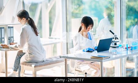 Femmes scientifiques travaillant sur leurs ordinateurs dans un laboratoire de recherche médicale moderne. Soins de santé, médecine, développement de la microbiologie Banque D'Images