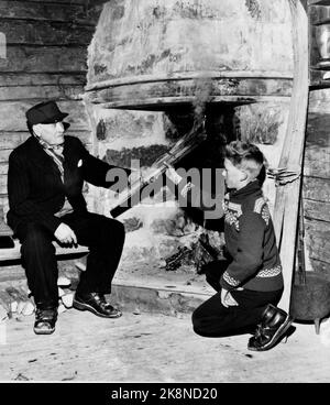 Morgedal 19520213. Les Jeux Olympiques d'hiver à Oslo: South Polar Far Olav Bjaaland allume le feu olympique à Grua dans le salon de Sondre Norheim à Morgedal. NTB photo: Knobelauch Banque D'Images