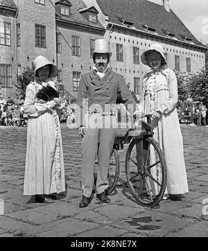 Bygdøy 19570825 Parade de vieux vélos au Musée Folk. Homme avec chapeau de soie dentaire et des vêtements contemporains et vieux vélo avec deux femmes, à la mode habillé avec de longues robes et baisers. Photo: Jan Nordby / NTB / NTB Banque D'Images