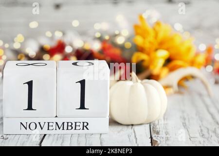 Journée des anciens combattants ou jour du souvenir. Blocs de calendrier en bois blanc avec la date 11 novembre et les décorations d'automne sur une table en bois. Mise au point sélective. Banque D'Images