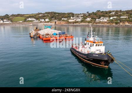 COVERACK, ROYAUME-UNI - 20 SEPTEMBRE 2022. Un bateau à remorqueurs et barge nautique délivrant de la pierre extraite pour permettre la réparation des défenses marines de Coverack, Cornw Banque D'Images