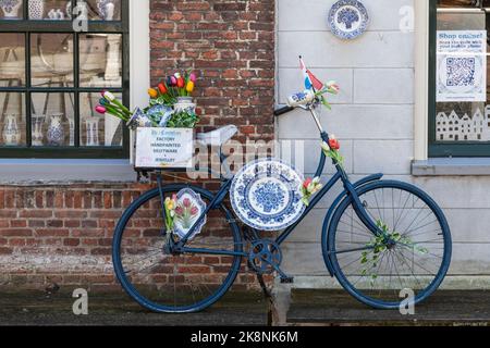 Vélo bleu avec la célèbre porcelaine bleue de Delft dans le centre de la ville hollandaise historique de Delft. Banque D'Images