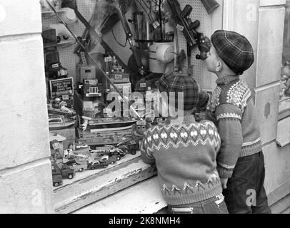 6 avril 1963. Les Norvégiens invitent Strømstad à couper jeudi. La tradition a commencé après la guerre quand la Norvège manquait de la plupart des marchandises. Les magasins de Norvège sont fermés le jeudi, donc vous devez faire un voyage en Suède pour remplir la voiture ou le bateau avec diverses marchandises. Voici deux petits garçons qui regardent des jouets dans une boutique de jouets. Photo: Ivar Aaserud / courant / NTB Banque D'Images