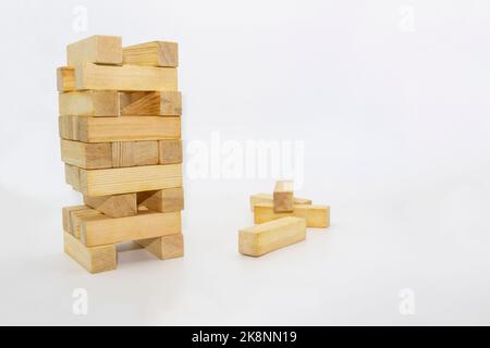 Tour en bois, construit tour à partir de blocs de bois sur fond blanc. Les briques de bois qui traînent au hasard Banque D'Images