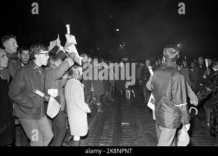 Oslo 19661210. Train au chalumeau contre la guerre au Vietnam. Plusieurs milliers d'entre eux ont participé à la manifestation pour la paix au Vietnam et pour avoir arrêté les bombardements américains sur le pays. Voici le train aux flambeaux sur le chemin de l'ambassade des États-Unis. Les manifestants du comptoir sur le trottoir (sur la photo) criaient des slogans aux manifestants. La police avec des chiens a suivi le train après avoir fumé des bombes et des bombes incendiaires ont été lancées contre le train de torchlight. Photo Paul Owesen / Arild Hordnes / NTB / NTB Banque D'Images