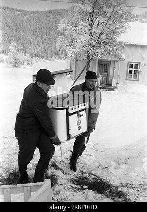 Trysil 19680107. Déluge de glace dans la rivière Trysil : la rivière Trysil a été inondée de grandes quantités de glace entre l'appareil et le sol, créant des inondations qui, en quelques jours, ont jeté sept petites fermes sous l'eau et menacé d'autres utilisations. Ici, ce qui est sauvé peut de la destruction de l'inondation. Deux hommes portent un poêle d'une ferme. Photo: NTB / NTB Banque D'Images