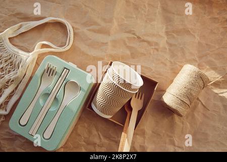 Vaisselle écologique jetable couverts, tasses en carton en matériaux naturels avec sac réutilisable sur papier froissé. Un mode de vie durable et sans gaspillage. Banque D'Images